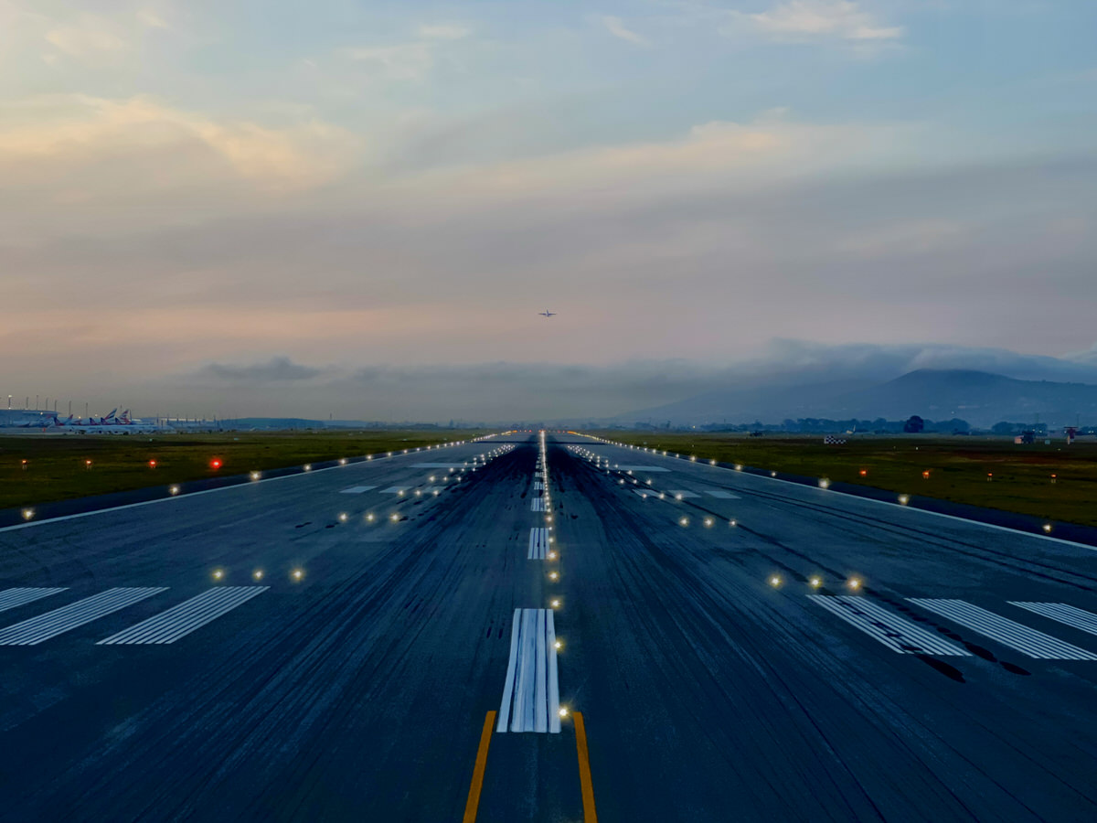 Startbahn mit Flugzeug am Horizont